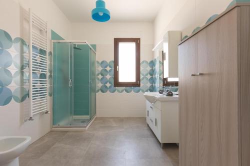 La salle de bains est pourvue d'une douche en verre et d'un lavabo. dans l'établissement Villa Sirio by Perle di Puglia, à Veglie