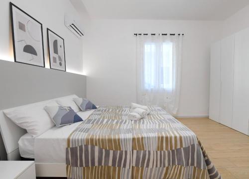 a white bedroom with a bed and a couch at A CANTUNERA in Balestrate