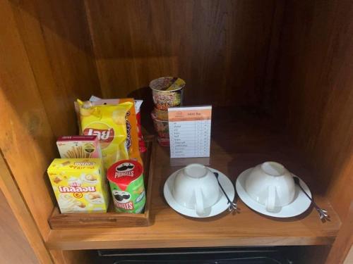 a shelf with two cups and a tea set on it at โรงแรม ณ สุโขทัย in Sukhothai