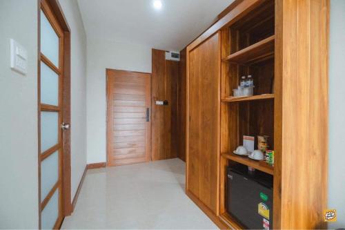 a hallway with a wooden closet and a door at Na Sukhothai Hotel in Sukhothai