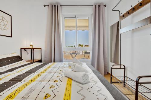 a bedroom with a large bed with yellow and white sheets at Vistamarina A409 By IVI Real Estate in Torremolinos