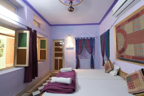 a bedroom with two beds and a window at Hotel Renuka in Jaisalmer