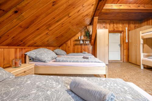 2 Betten in einem Zimmer mit Holzwänden in der Unterkunft Lysečinská bouda in Horní Maršov