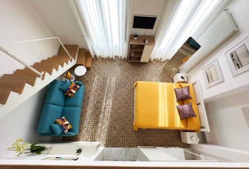 - une vue de tête sur un salon avec des chaises et des escaliers jaunes dans l'établissement MARGHERITA 109, à Naples