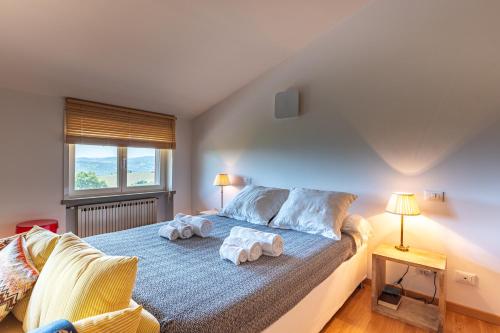 a bedroom with a bed with towels on it at Exclusive Duplex Villa con piscina e vista in Strognano