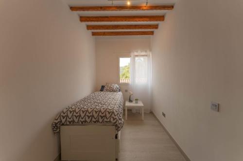a bedroom with a bed in a white room at Finca Artiles in Las Palmas de Gran Canaria