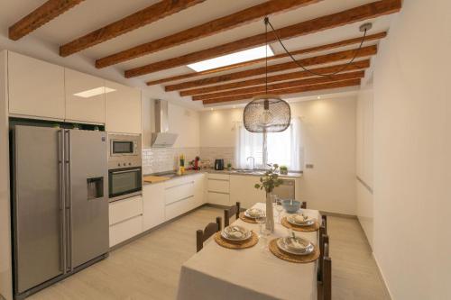 una cucina e una sala da pranzo con tavolo e frigorifero di Finca Artiles a Las Palmas de Gran Canaria