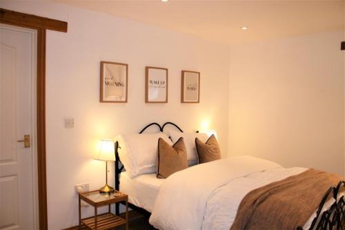 1 dormitorio con 1 cama con sábanas y almohadas blancas en Oak Cottage - Near Abergavenny, en Abergavenny
