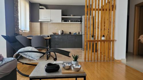 ein Wohnzimmer mit einem Tisch und einer Küche in der Unterkunft Apartman Riva in Kraljevo