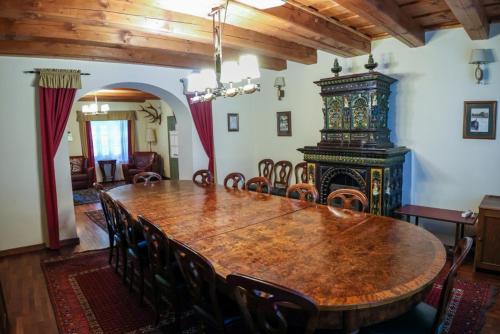 una sala da pranzo con un grande tavolo in legno e sedie di Wenckheim Vadászház a Nagyoroszi