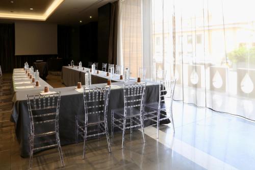 a long table with chairs in a room with windows at Klima Hotel Milano Fiere in Milan