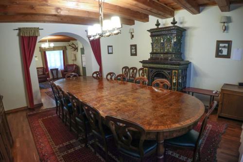 a dining room with a wooden table and chairs at Wenckheim Vadászház in Nagyoroszi