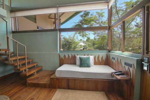 a bedroom with a bed in a room with a window at Tadoba Jungle Camp in Mohurli