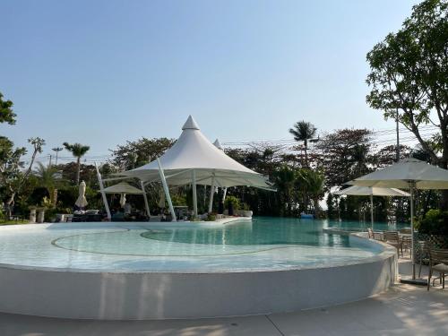 a swimming pool with umbrellas and a swimming pool at Copacabana jomtien beach high floor in Jomtien Beach