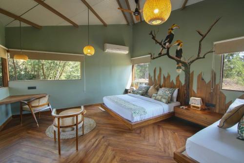 Schlafzimmer mit einem Bett, einem Tisch und Stühlen in der Unterkunft Tadoba Jungle Camp in Mohurli
