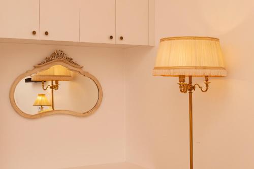 a lamp and a mirror on a wall at Aires da Serra Hotel in Torres Novas