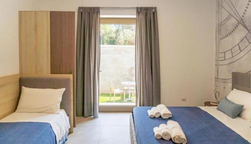 a bedroom with two beds with towels on them at Cinque Venti BB Porto Cesareo in Porto Cesareo