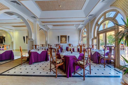 a dining room with purple tables and chairs at Makadi Palace - Couples and Families Only in Hurghada