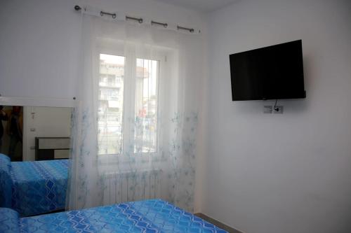 een slaapkamer met een bed en een flatscreen-tv bij Donna Paola in Pompei