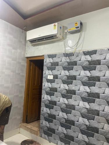 a bathroom with a tile wall with a heater at Suraj Bhawan in Gaya