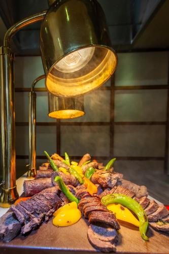 a pile of meat and vegetables on a cutting board at Makadi Palace - Couples and Families Only in Hurghada