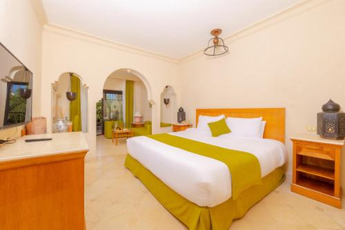 a bedroom with a large bed and a desk at Makadi Palace - Couples and Families Only in Hurghada