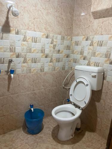 uma casa de banho com WC e um balde azul em Suraj Bhawan em Gaya