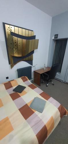 um quarto com uma cama, uma secretária e uma cadeira em Calipso1 em Niš