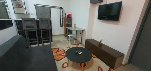 uma sala de estar com uma mesa e uma televisão em Calipso1 em Niš