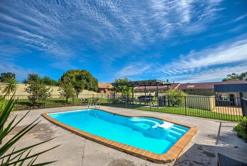 a swimming pool in a yard with a fence at Country Capital Motel in Tamworth