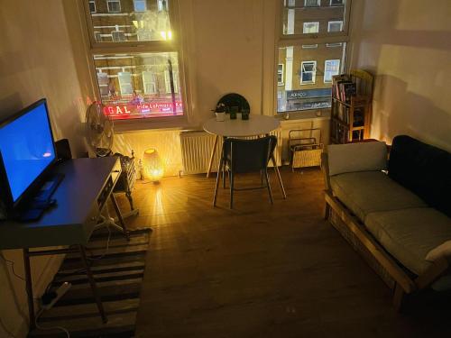 a living room with a couch and a table with a tv at Very Lovely and Central 1-Bed Apartment in London in London