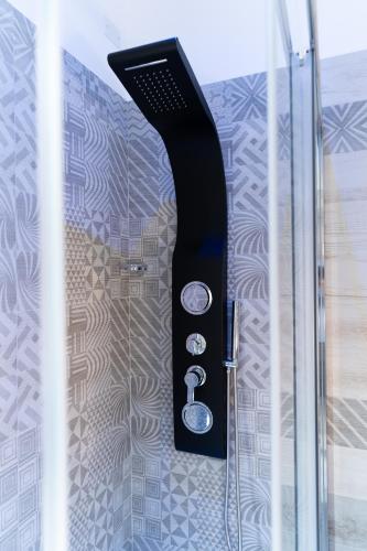a glass shower door with a black shower at B&B Golden House & spa in Rose