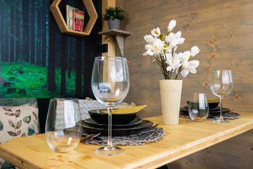 a wooden table with wine glasses and a vase of flowers at Tiny House Honzík in Světlík