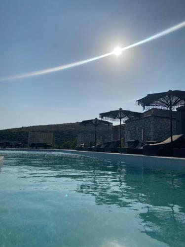 a swimming pool with blue water and umbrellas at Ktima Papadopoulou in Krionérion