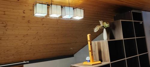 a room with a wooden ceiling with two lights and a shelf at Apartman Bernardica in Bol