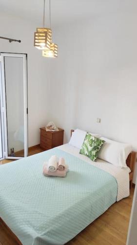 ein Schlafzimmer mit einem Bett mit zwei Hausschuhen darauf in der Unterkunft Serenity apartment in Kóronos