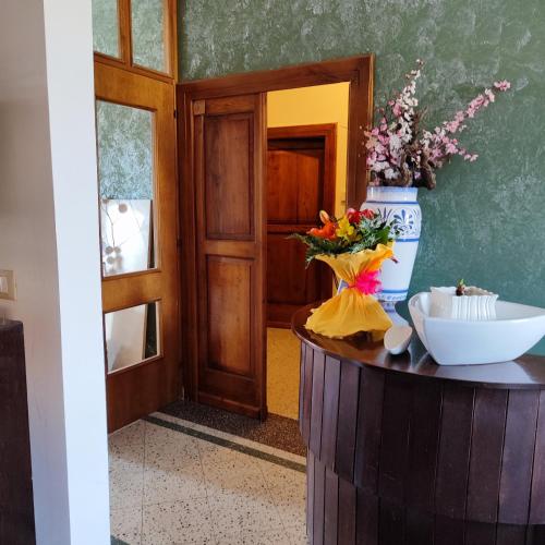 a room with a table with a vase of flowers on it at B&B Home Holiday Villa delle Acacie agriturismo in Sala Consilina