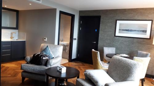 a living room with two chairs and a table at Grand Central Hotel Belfast in Belfast