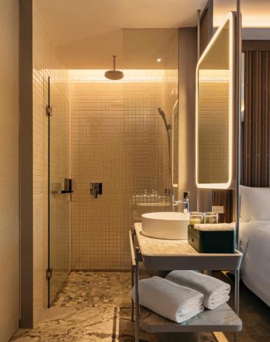 a bathroom with a shower and a sink and a tub at Pan Pacific Orchard in Singapore