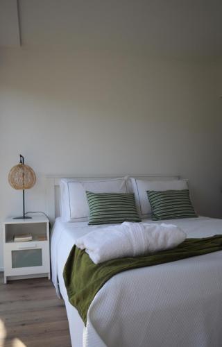 a white bed with two pillows on top of it at Refugio D Alecrim in Paredes