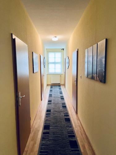 um corredor com portas e piso em azulejo num quarto em Euphrat Pension em Lichtentanne
