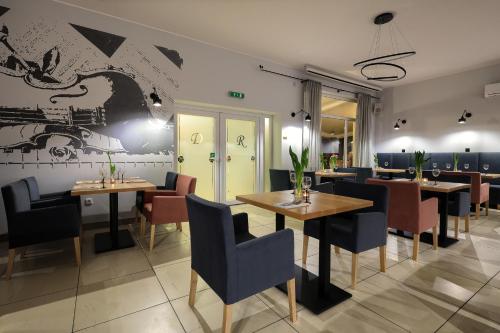 restauracja ze stołami i krzesłami oraz muralem w obiekcie Dworek Różany Hotel & Restauracja w mieście Namysłów