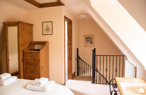 ブロードウェイにあるSheldon Cottageのベッドルーム1室(ベッド1台、階段付)