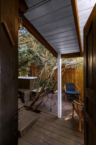 a porch with a bench and a bath tub at Live in the woods in Mikhmannim