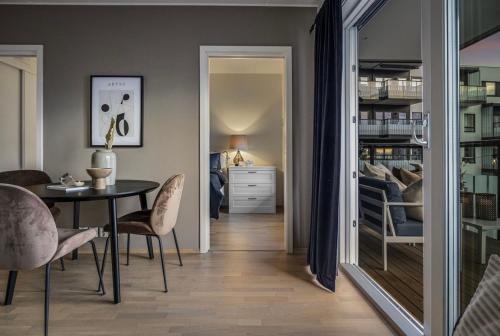 a dining room with a table and chairs and a bedroom at Private room in sharded apartment at Løren in Oslo