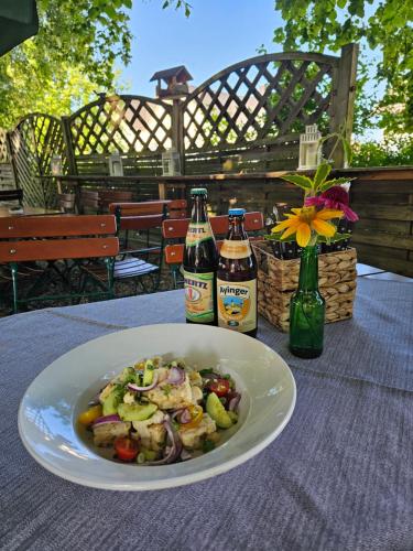 a plate of food on a table with two bottles of beer at Gasthof Klement in Isen