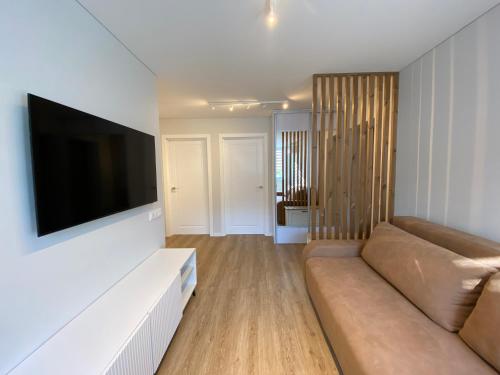 a living room with a couch and a flat screen tv at Pas Gerarduka in Nida