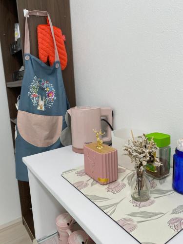 a counter with a table with a bag and flowers at Arts Candy Sapporo-Villa Nakajima in Sapporo