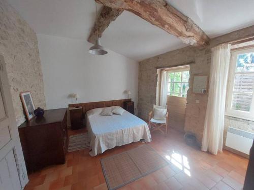 1 dormitorio con cama, mesa y ventana en Maison en pierre à Laroque-Timbaut - Clévacances 3 clés, en Laroque-Timbaut
