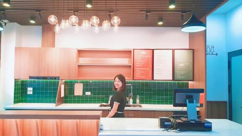 a woman standing at a counter in a restaurant at Xan hotel Phu Quoc in Phú Quốc
